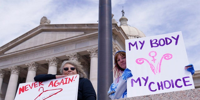 Dani Thayer, left, and Marina Lanae, right, both of Tulsa, Oklahoma, hold pro-choice signs at the state Capitol, Wednesday, April 13, 2022, in Oklahoma City.