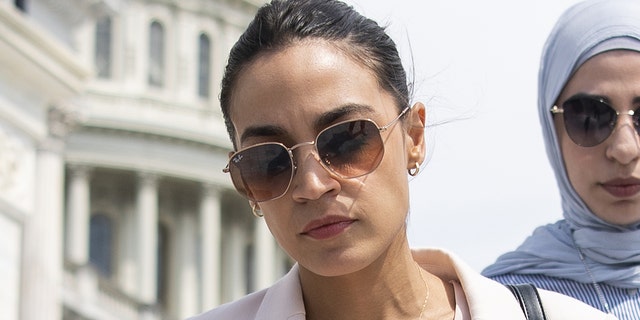 Rep. Alexandria Ocasio-Cortez, D-N.Y., talks with a reporter as she walks down the House steps, July 1, 2021. 