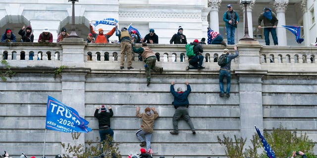 Supporters of President Donald Trump climb the west wall of the U.S. Capitol on Wednesday, Jan. 6, 2021, in Washington. (AP Photo/Jose Luis Magana)