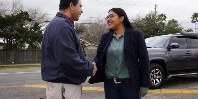 Democrat Jessica Cisneros, who is campaigning for a House seat, greets her opponent, U.S. Rep. Henry Cuellar, D-Texas, for the first time on the campaign trail at the Citrus Parade in Mission, Texas, Jan. 25, 2020. 