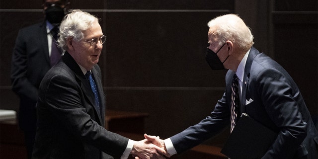 President Biden shakes hands with Senate Minority Leader Mitch McConnell.