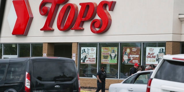 A crowd gathers as police investigate after a shooting at a supermarket on Saturday, May 14, 2022, in Buffalo, N.Y. Multiple people were shot  at the Tops Friendly Market.  Police have notified the public that the alleged shooter was in custody. 