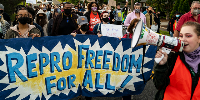 ALEXANDRIA, VA - MAY 09: Abortion-rights advocates mach in the street to stage a protest outside the house of Supreme Court Associate Justice Samuel Alito in the Fort Hunt neighborhood on Monday, May 9, 2022 in Alexandria, VA. (Kent Nishimura / Los Angeles Times via Getty Images) 