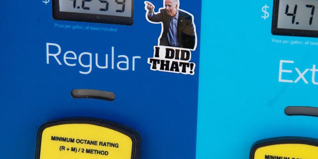 A gas pump displays current fuel prices, along with a sticker of President Joe Biden, at a gas station in Arlington, Virginia, on March 16, 2022. 