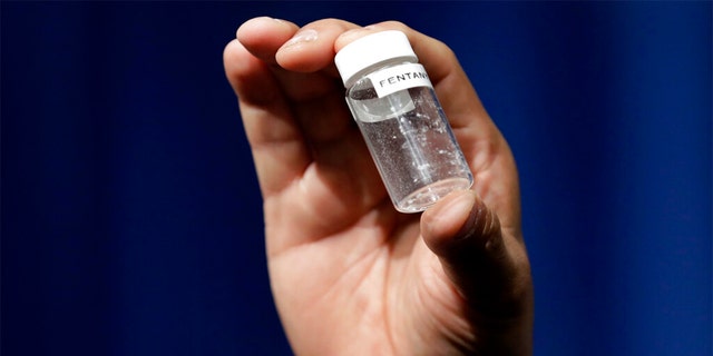 A reporter holds up an example of the amount of fentanyl that can be deadly after a news conference about deaths from fentanyl exposure, at DEA Headquarters in Arlington, Virginia. 