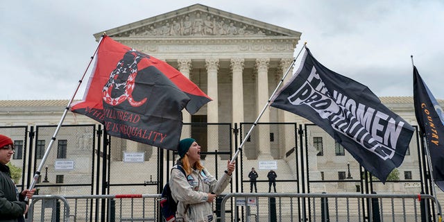Abortion-rights protesters wave flags during a demonstration outside of the U.S. Supreme Court, Sunday, May 8, 2022, in Washington. A draft opinion suggests the Supreme Court could be poised to overturn the landmark 1973 Roe v. Wade case that legalized abortion nationwide, according to a Politico report released Monday. 