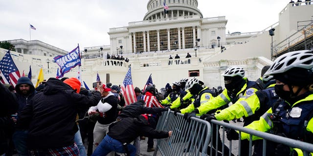 Trump supporters try to break through a police barrier, Wednesday, Jan. 6, 2021, at the Capitol in Washington. (AP Photo/Julio Cortez)