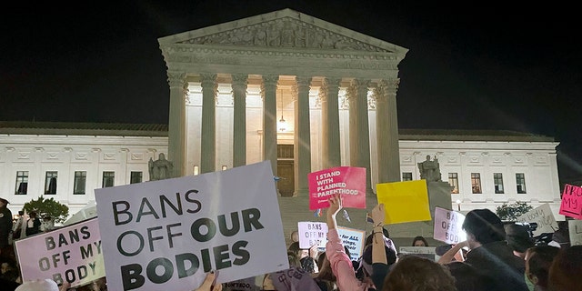 A crowd of people gather outside the Supreme Court, Monday night, May 2, 2022, in Washington following reports of a leaked draft opinion by the court overturning Roe v. Wade.