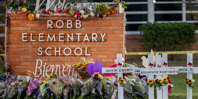 A memorial is seen surrounding the Robb Elementary School sign following the mass shooting at Robb Elementary School on May 26, 2022 in Uvalde, Texas. 