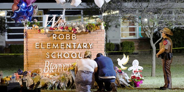 Stephanie and Michael Chavez of San Antonio pay their respects at a makeshift memorial outside Robb Elementary School in Uvalde, Texas, May 25, 2022.