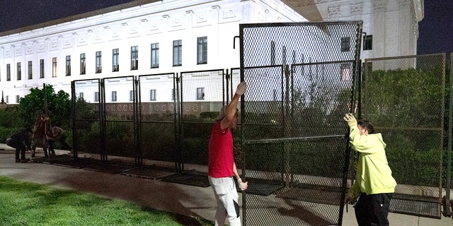 Workers assemble non-scalable fences around the Supreme Court Building amid ongoing abortion-rights demonstrations on May 4, 2022, in Washington, D.C. 