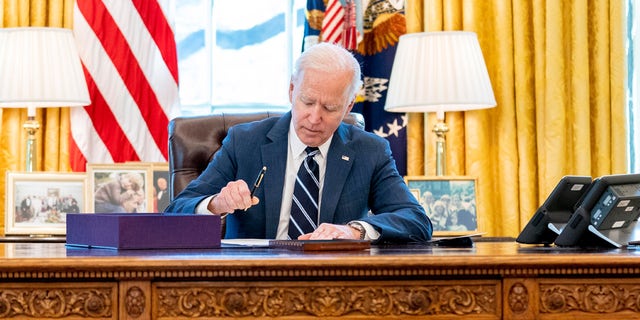 President Joe Biden signs the American Rescue Plan, a coronavirus relief package, in the Oval Office of the White House, Thursday, March 11, 2021, in Washington. 