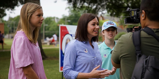 Alabama Senate candidate Katie Britt stands alongside her son and daughter as she speaks to members of the media after voting in Montgomery on May 24, 2022.