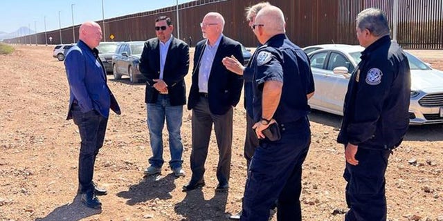 Sen. Mark Kelly talks with CBP personnel at the border in Douglas, Ariz. 