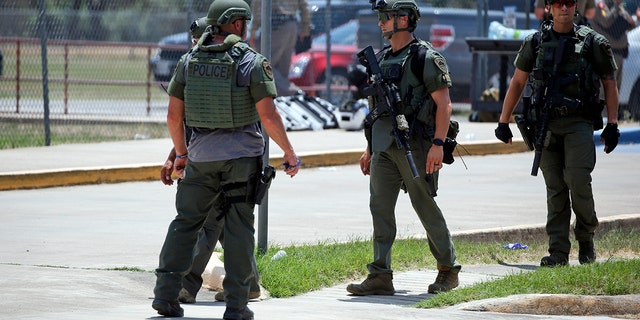 Law enforcement personnel stand outside Robb Elementary School following a shooting, Tuesday, May 24, 2022, in Uvalde, Texas. 