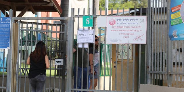 Parents enter a school in Kiryat Ono, Israel