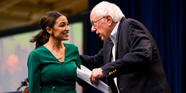 DES MOINES, IA - NOVEMBER 09: U.S. Rep. Alexandria Ocasio-Cortez (D-NY) is joined on stage by Democratic Presidential candidate Bernie Sanders (I-VT) during the Climate Crisis Summit at Drake University on November 9, 2019 in Des Moines, Iowa. Sanders, Ocasio-Cortez, and author Naomi Klein spoke about the current state of climate change in relation to U.S. policy. 