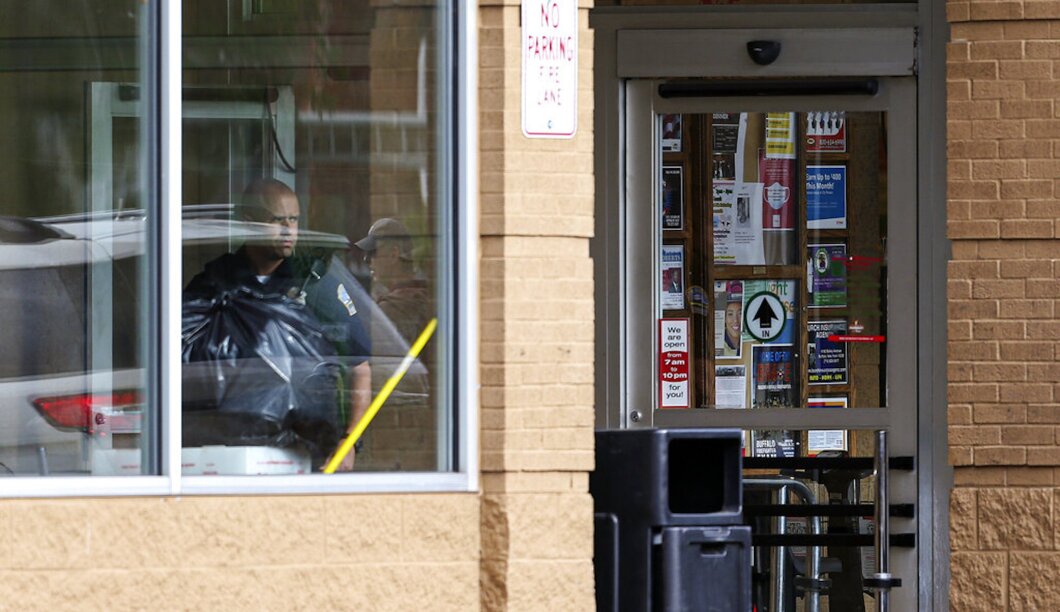 A police officer looks out the window as law enforcement officers investigate after a shooting at a supermarket on Saturday in Buffalo, New York.