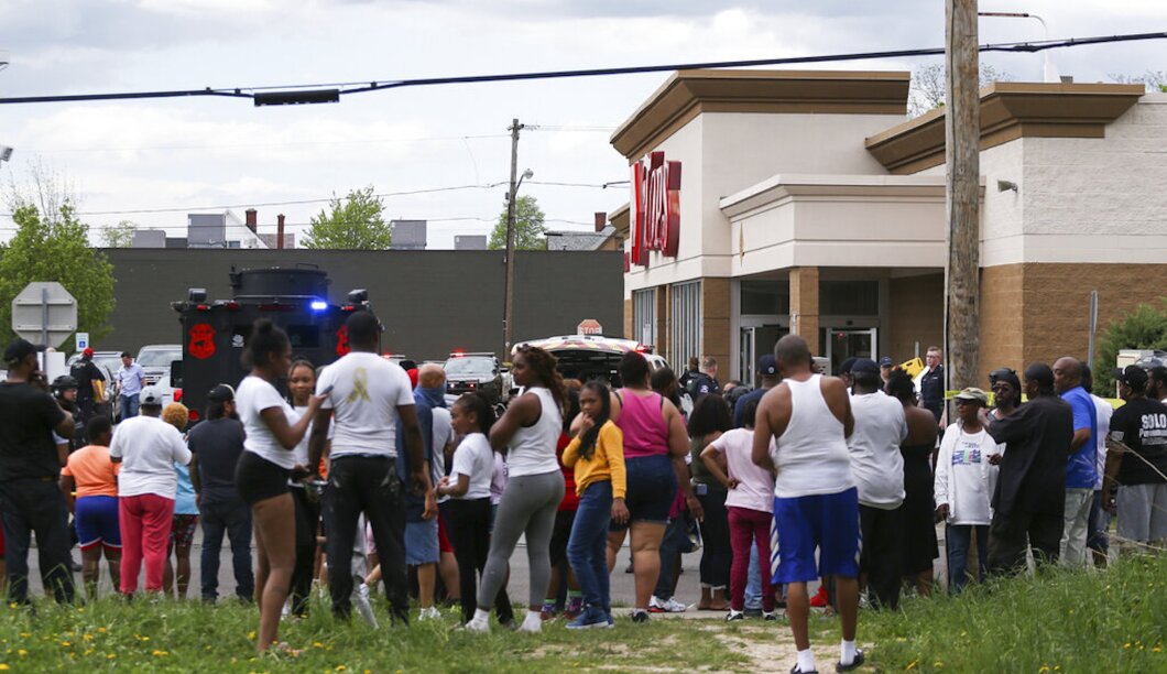 A crowd gathers as police investigate after a shooting at a supermarket on Saturday in Buffalo, New York. Multiple people were shot at the Tops Friendly Market. Police have notified the public that the alleged shooter was in custody. 