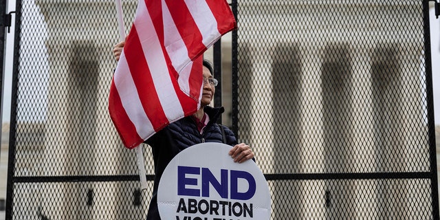 A pro-life demonstrator stands in front of a fence that stands around the Supreme Court in Washington, on May 5, 2022. (Jim Watson/AFP via Getty Images)