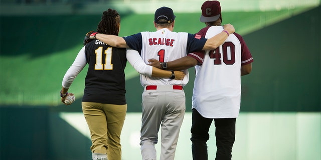 Capitol Police Special Agents Crystal Griner and David Bailey assist U.S. Rep. Steve Scalise to his position at second base at the start of the 57th Congressional Baseball Game at National's Park in Washington, Thursday, June 14, 2018, a year after he was wounded in an assassination attempt.