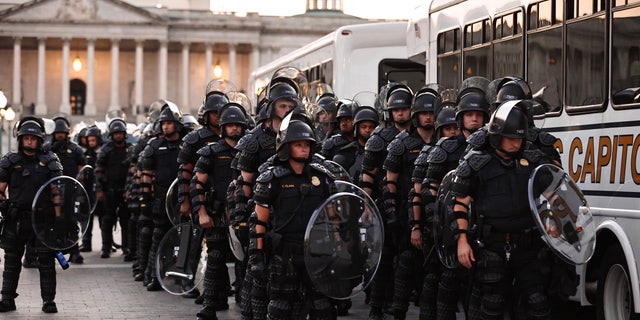 Capitol police stand dressed in riot gear as protestors gather near the Supreme Court in response to the ruling on Roe v. Wade.