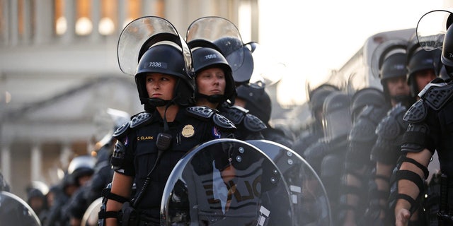 Capitol police stand dressed in riot gear as protestors gather near the Supreme Court in response to the ruling on Roe v. Wade.