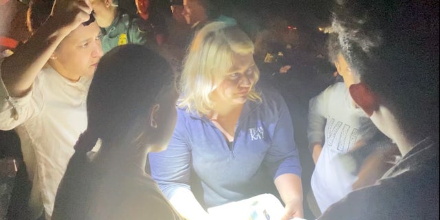 Reps. Kat Cammack, R-Fla., and Stephanie Bice, R-Okla., speak to a group of migrants apprehended by the Texas National Guard. 