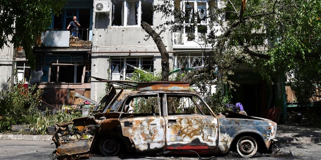 A destroyed car lies next to an apartment building damaged by an overnight missile strike in Sloviansk, Ukraine, Tuesday, May 31, 2022.