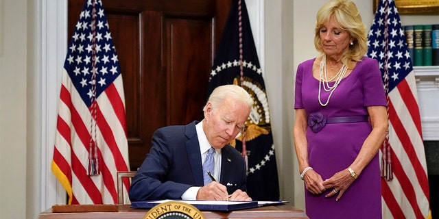 President Biden signs into law the Bipartisan Safer Communities Act gun safety bill in the Roosevelt Room of the White House in Washington Saturday, June 25, 2022. First lady Jill Biden looks on at right. 