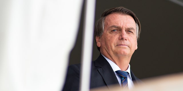 President of Brazil Jair Bolsonaro reacts during the exchange of the presidential guard at Planalto Palace on December 16, 2021 in Brasilia, Brazil. 