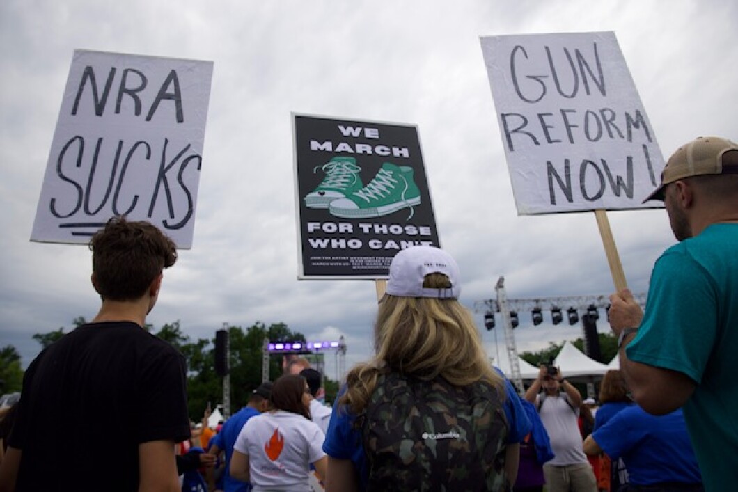 Signs reading, "Gun reform now!", "NRA sucks," and "We march for those who can't," are seen in Washington on Saturday.