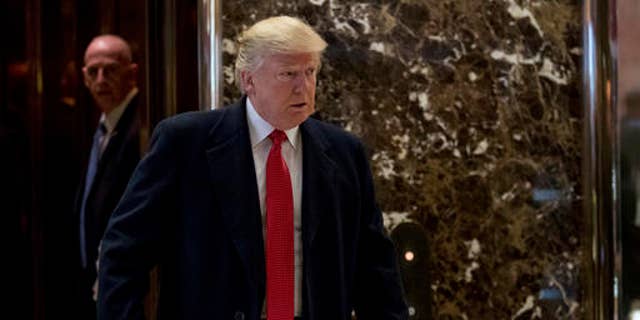 President-elect Donald Trump comes to the lobby to speak to members of the media at Trump Tower in New York, Tuesday, Dec. 6, 2016.