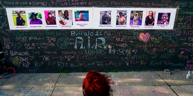 A person visits a makeshift memorial near the scene of Saturday's shooting at a supermarket, in Buffalo, on May 19, 2022, six days before the second anniversary of George Floyd's killing.