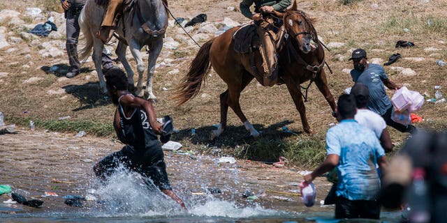 U.S. Customs and Border Protection mounted officers attempt to contain migrants as they cross the Rio Grande from Ciudad Acuña, Mexico, into Del Rio, Texas, Sunday, Sept. 19, 2021. 