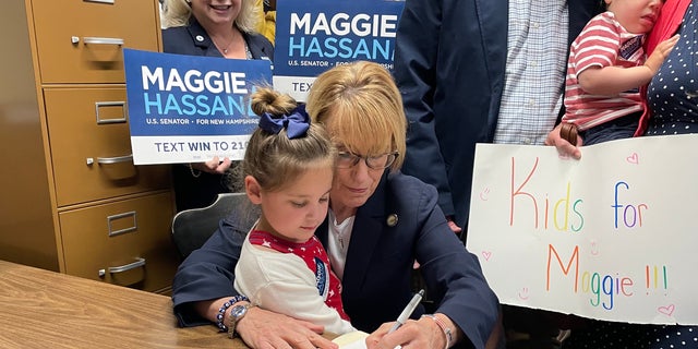 Democratic Sen. Maggie Hassan of New Hampshire, with the daughter of a friend sitting in her lap, formally files for reelection, on June 10, 2022 in Concord, N.H. 