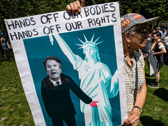An activist carries a placard with an image of US Supreme Associate Justice Brett Kavanaugh during a Planned Parenthood Pro-Choice Rally in Boston, Massachusetts, on May 14, 2022. - Thousands of activists are participating in a national day of action calling for safe and legal access to abortion. The nationwide demonstrations are a response to leaked draft opinion showing the US Supreme Court's conservative majority is considering overturning Roe v. Wade, the 1973 ruling guaranteeing abortion access. (Photo by Joseph Prezioso / AFP) (Photo by JOSEPH PREZIOSO/AFP via Getty Images)