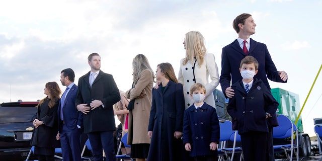 From left, Donald Trump Jr., and his girlfriend Kimberly Guilfoyle, Eric Trump and his wife Lara Trump and their children and Ivanka Trump and her husband Jared Kushner and their children Theodore, Joseph and Arabella wait for President Donald Trump to arrive at Andrews Air Force Base, Md., Wednesday, Jan. 20, 2021 .(AP Photo/Manuel Balce Ceneta)