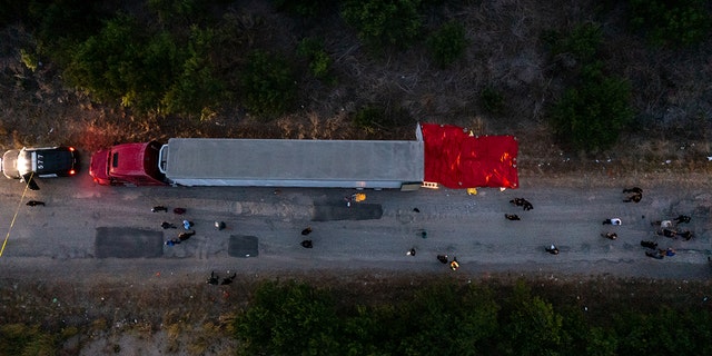 In this aerial view, members of law enforcement investigate a tractor trailer on June 27, 2022, in San Antonio, Texas. Forty-six migrants were found dead in an abandoned tractor trailer, and seven more died later. 