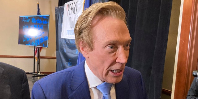 Michigan gubernatorial candidate Perry Johnson, a Republican, briefly speaks with reporters, Feb. 23, 2022, after a kickoff event at a hotel in Lansing, Mich.