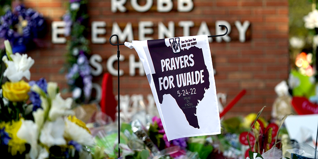 A banner hangs at a memorial outside Robb Elementary School on Friday, June 3.