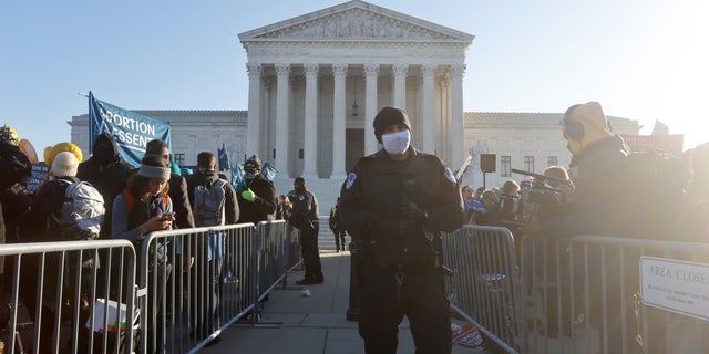 Supreme Court Police officers guard a barrier between anti-abortion and pro-abortion rights protesters outside the court building, ahead of arguments in the Mississippi abortion rights case Dobbs v. Jackson Women's Health, in Washington, U.S., December 1, 2021. REUTERS/Jonathan Ernst