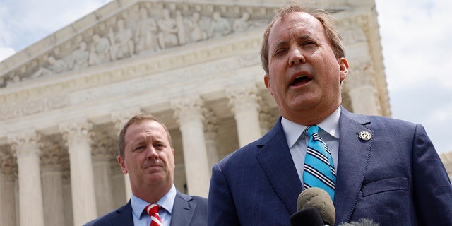 Texas Attorney General Ken Paxton (R) and Missouri Attorney General Eric Schmitt talk to reporters after the U.S. Supreme Court heard arguments in their case about Title 42 on April 26, 2022, in Washington, D.C.