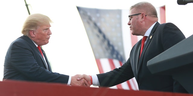 Illinois Gubernatorial hopeful Darren Bailey greets Donald Trump after receiving an endorsement during a Save America Rally with former US President Donald Trump at the Adams County Fairgrounds on June 25, 2022 in Mendon, Illinois.