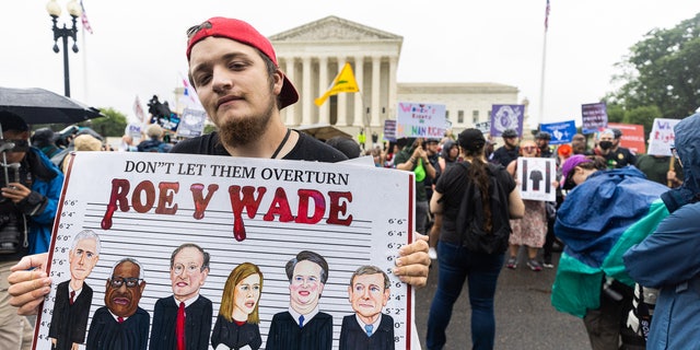 Protesters are seen outside the Supreme Court Thursday morning.