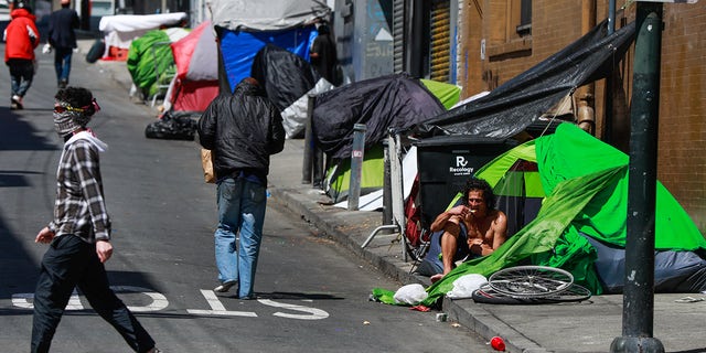 Homeless people gather on Willow Street in the Tenderloin on May 6, 2020, in San Francisco.