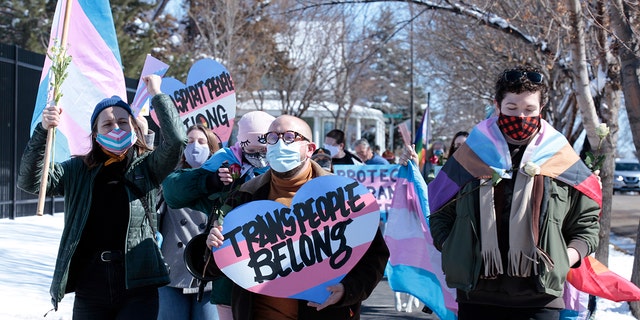 Advocates for transgender people march from the South Dakota governor's mansion to the Capitol in Pierre, S.D., on March 11, 2021.