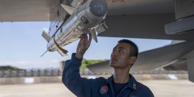 A soldier checks the missiles on an air fighter at a PLA military airport during a training session in east China's Zhejiang province in late August 2021. 