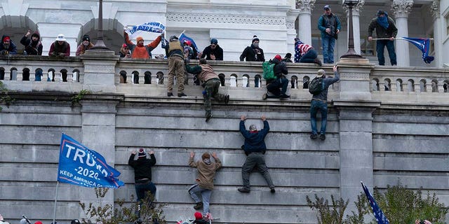 Supporters of President Donald Trump climb the west wall of the U.S. Capitol on Wednesday, Jan. 6, 2021, in Washington.