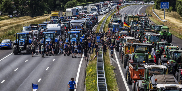 Farmers gather with their vehicles next to a Germany/Netherlands border sign during a protest on June 29, 2022, against the Dutch government's nitrogen plans.